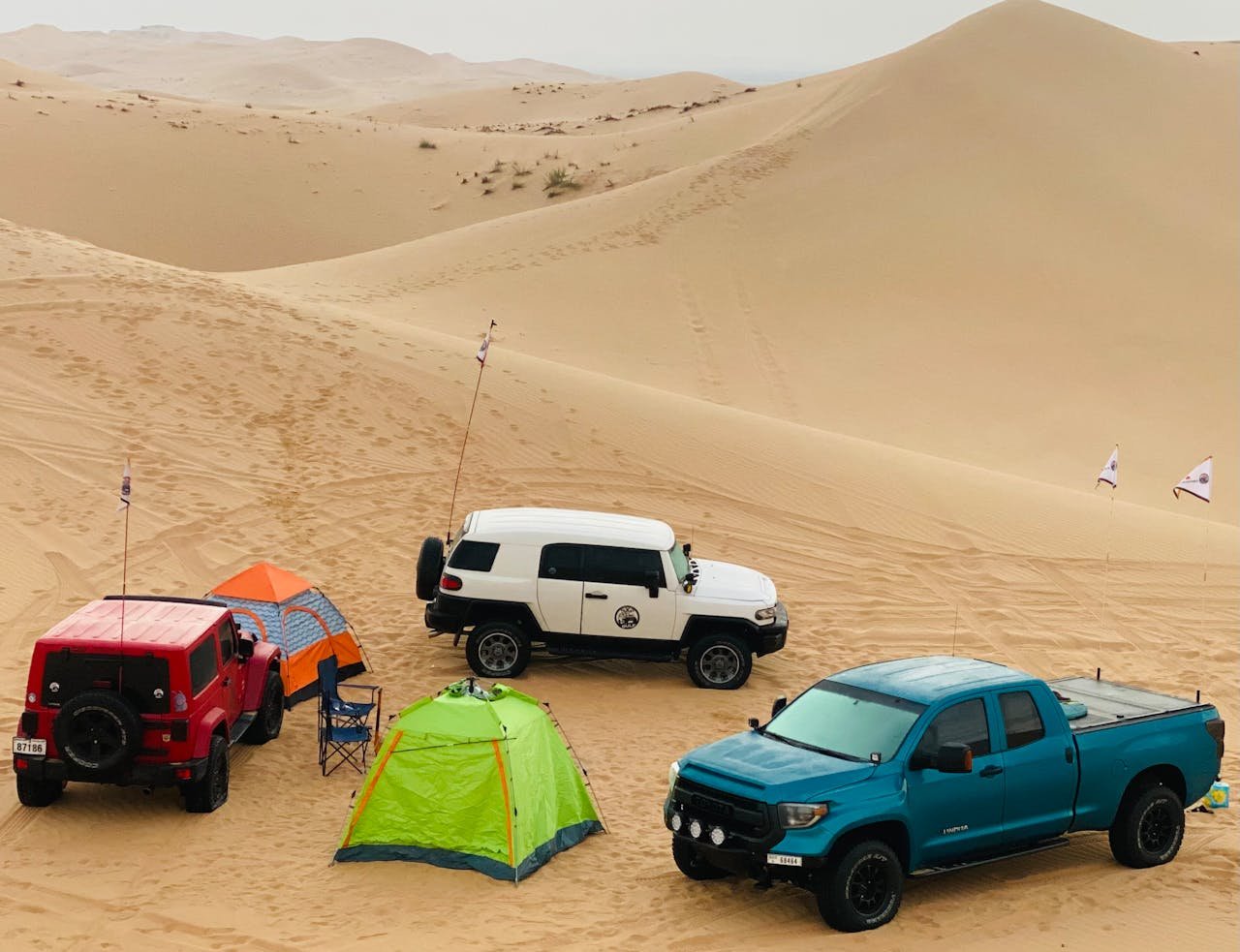 digital Off-road vehicles and tents in Abu Dhabi desert landscape perfect for adventure trips.